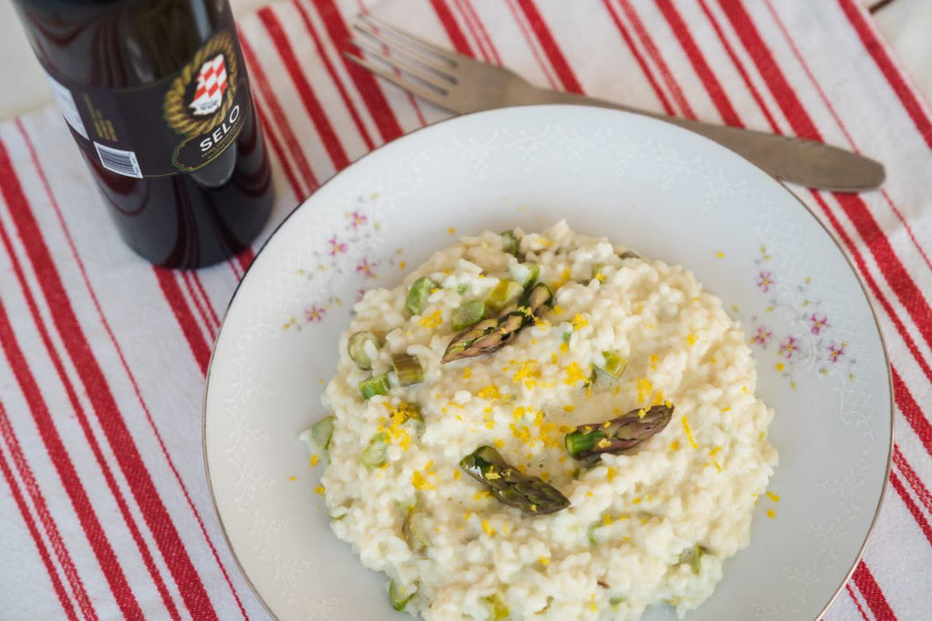 Creamy Lemon Asparagus Risotto drizzled with Croatian olive oil, served in a stylish bowl and garnished with fresh asparagus tips and lemon zest, showcasing a vibrant and delicious springtime dish.