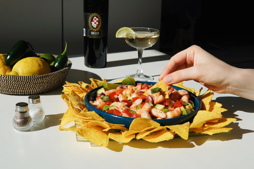 Image of a bowl of vibrant Ceviche with Shrimp and Avocado, garnished with cilantro, accompanied by tortilla chips on the side.