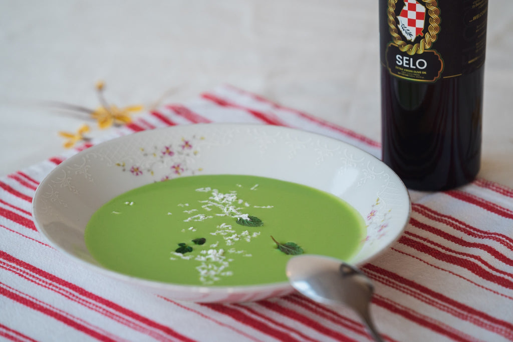 Cream of Spring Pea Soup - A creamy and vibrant green soup garnished with fresh mint leaves, served in a bowl.